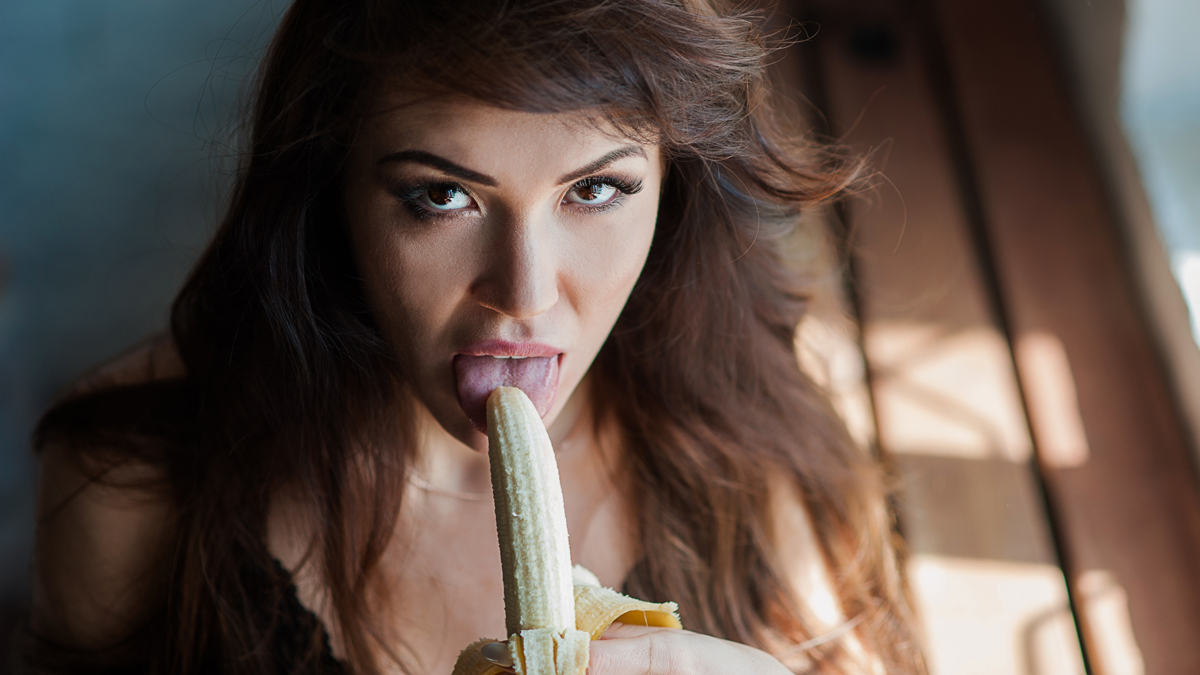 Frau hält Banane an ihre Lippen